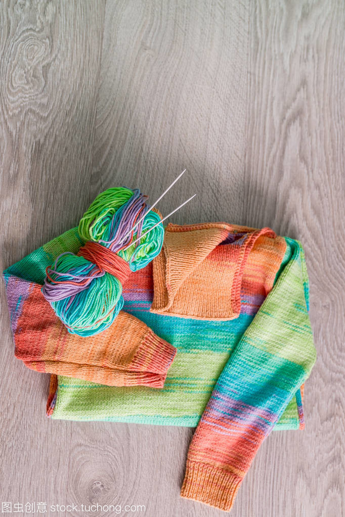 針織。針織毛衫。多色球的紗線用針附近上木制的灰色背景的手工產品。頂視圖。復制空間